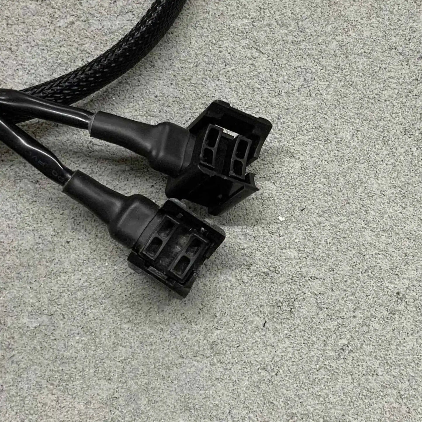 Back two black electrical connectors on a gray surface