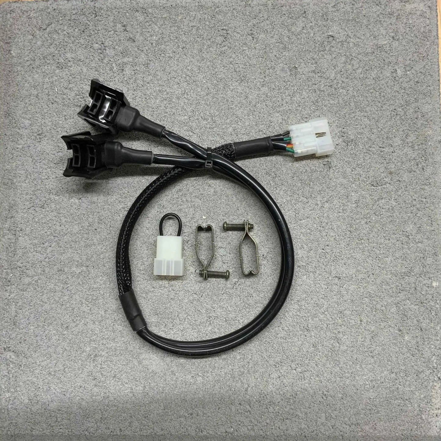 Back of automotive wiring harnesses and connectors on a gray surface