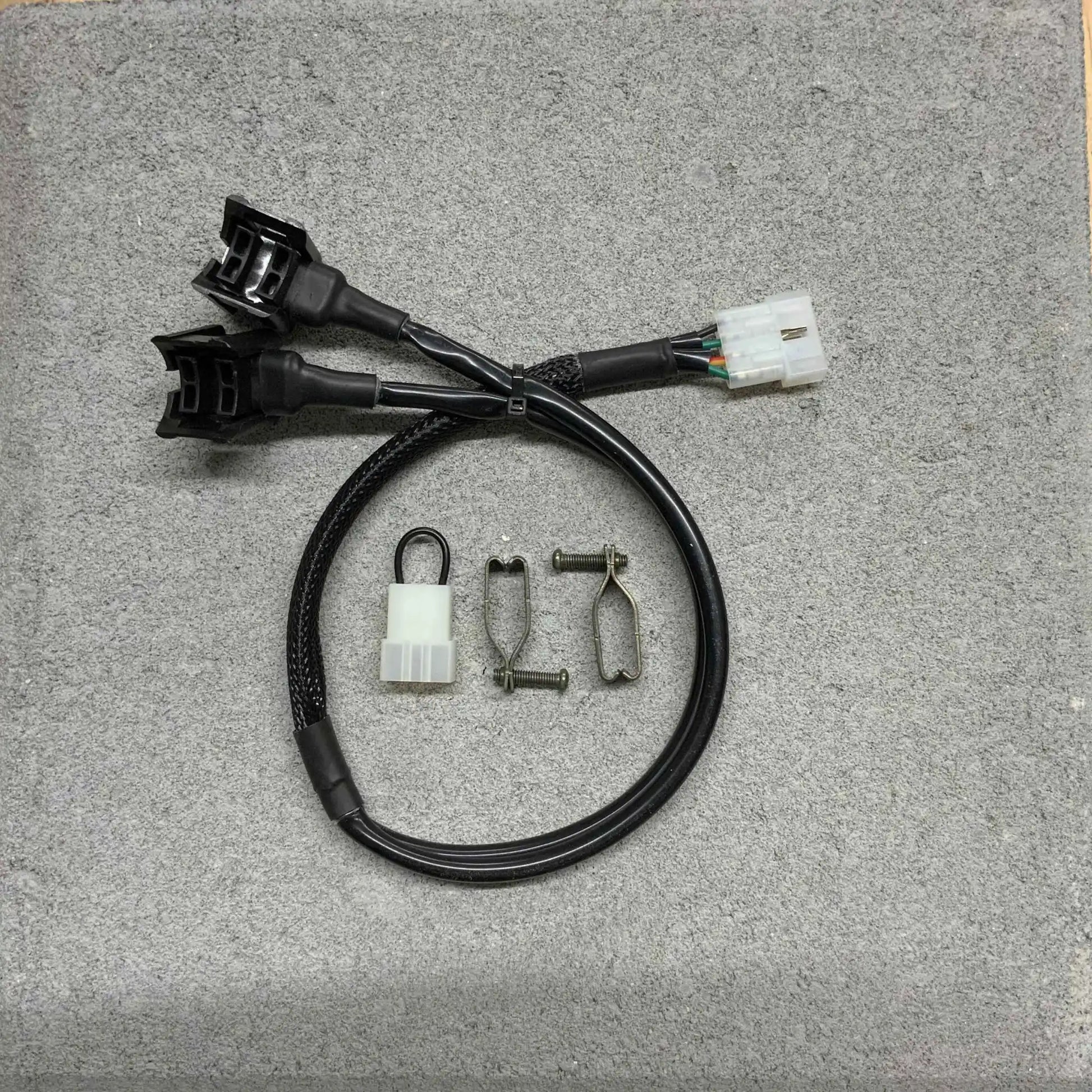 Back of automotive wiring harnesses and connectors on a gray surface